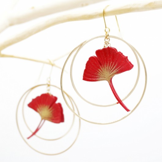 Ginko leaf earring framed by two gold-plated hoop earrings